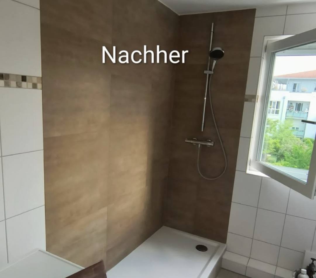 Bad nach der Sanierung: bodengleiche Dusche mit großformatigen Wandplatten in warmer Holzoptik